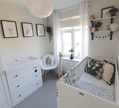 a baby's room with white furniture and pictures on the wall