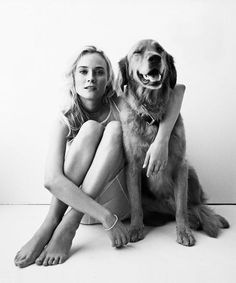 a woman is sitting on the floor with her dog, black and white photo in color