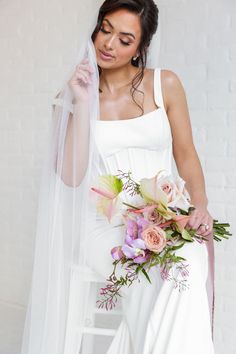 A Bride Holding A Bouquet Looking Off To The Side Holding Her Bouquet.