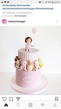 a pink cake with stuffed animals on top