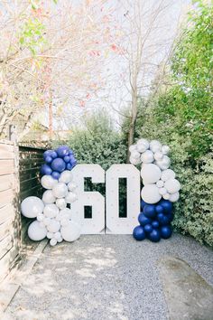 the number 50 is surrounded by balloons and streamers in blue, white and silver