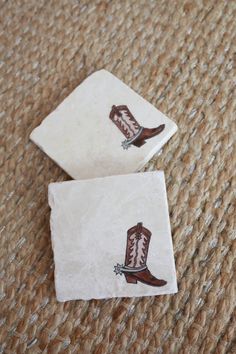 two square coasters with cowboy boots on them