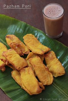 some food on a green leaf next to a drink