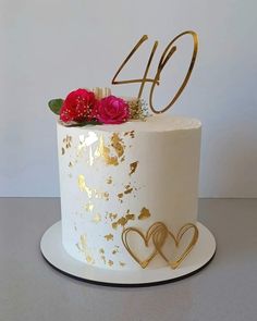 a white and gold cake with flowers on top