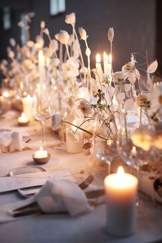 the table is set with white flowers and candles