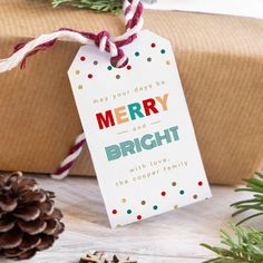 a merry and bright gift tag sitting on top of a present wrapped in brown paper