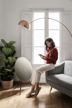 a woman sitting on a couch looking at her phone