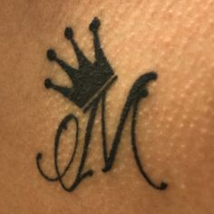 a tattoo with the letter m and a crown on it