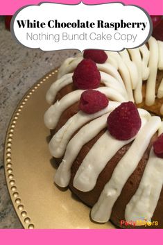 a white chocolate raspberry bundt cake with icing on a gold plate