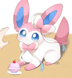 a pink and blue bunny holding a cupcake with one hand while another holds the other