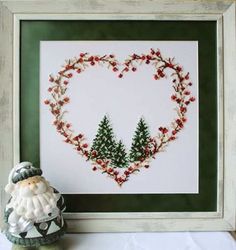 a cross stitch christmas heart with pine trees