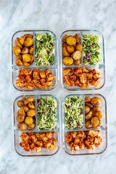 four plastic containers filled with food on top of a white countertop next to a marble table