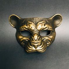 This golden panther mask captures the essence of a mighty panther, infusing your look with fierceness and undeniable presence. From Halloween parties to themed events and masquerade parties, our panther mask is the purr-fect addition to any look! Age Group/Gender - Adult/Men Size/Type - One size fits all adults Mask Color - Gold Mask Material - Polyresin Diy Masquerade, Diy Masquerade Mask, Mardi Gras Masks, Masquerade Ball Mask, Lion Mask, Golden Lions, Animal Mask, Gold Mask, Mask Masquerade