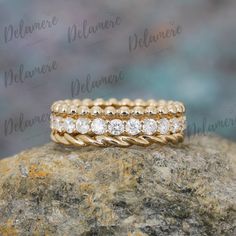 a yellow gold wedding band set with three round diamonds on top of a large rock