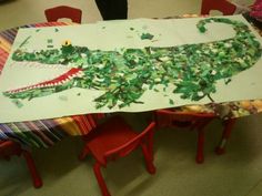 a child's drawing of a crocodile on a table with red chairs around it