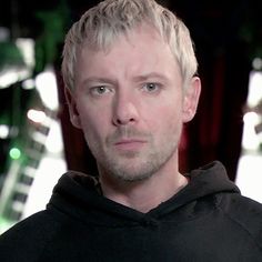 a man with blonde hair wearing a black hoodie