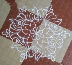 an intricately designed design on the ground in front of a tiled floor with red and white tiles