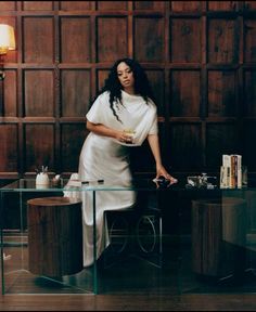 a woman standing in front of a glass table