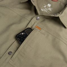 The Farmhand Overshirt is our take on the shirt jack. This work shirt layers over your tees or button-ups as a secondarily layer of warmth and protection. This cotton-performance outer shell keeps the elements out so you can be comfortable all day. Outer layer shell snap-up shirt Hidden Secure Cellphone zipper chest pocket Hidden snap down collar Anti-microbial Stain Resistance Extreme Durability Water Resistant Product Composition: 100% Cotton Style: A1500009 Utility Tops With Pockets For Outdoor, Utility Style Tops With Pockets For Outdoor, Techwear Top With Pockets For Outdoor Activities, Khaki Button-up Top For Outdoor, Khaki Buttoned Tops For Outdoor, Button-up Tops With Pockets For Outdoor, Durable Casual Khaki Outerwear, Urban Tops With Pockets For Outdoor Activities, Casual Durable Khaki Outerwear