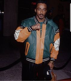 a man in an orange and green jacket holding a bag