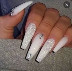 a woman's hand with white and silver nails