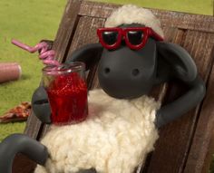 a fake sheep wearing sunglasses and holding a drink