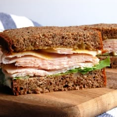 a cut in half sandwich sitting on top of a wooden cutting board