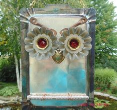 an owl statue with two large flowers on it's face and red glass eyes