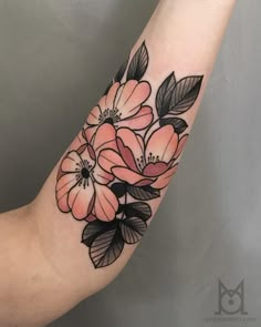 a woman's arm with flowers on it and leaves around the wrist tattoo design