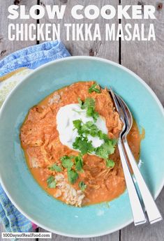 slow cooker chicken tikka masala in a blue bowl with a fork and napkin