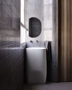 a white sink sitting under a bathroom mirror next to a wall mounted faucet