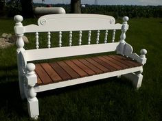 a white wooden bench sitting in the grass