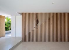 an empty room with wood slats on the wall and flooring in front of it