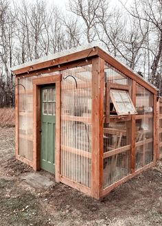 a small wooden building sitting in the middle of a field