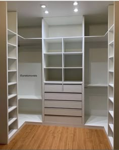 an empty walk in closet with lots of shelves and drawers on the wall, next to a hard wood floor