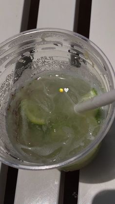 a cup filled with ice and cucumbers on top of a table