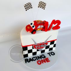 a cake that is shaped like a race car on top of a checkered box