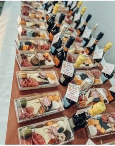 a table filled with lots of different types of cheeses and bottles of wine on top of it