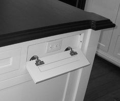 a black and white photo of a kitchen counter with two faucets on it