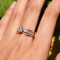 a woman's hand with two diamond rings on her left and the middle finger