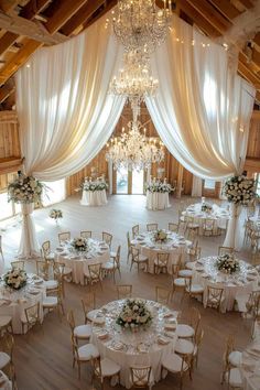 an indoor wedding venue with chandeliers and tables set up for a formal function