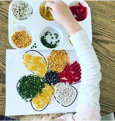 a child is making a flower made out of cereals and other things on the table