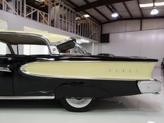 an old black and white car parked in a garage