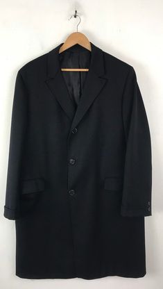 "-Description- >men's black wool overcoat >collared >three button front >two flap close pockets on the front >two buttons on the cuffs >lined >vent in the back >size large >perfect for a business coat! >condition: great >color(s): black >fabric(s): wool >brand: hymans clothes >care: dry clean -Measurements- >size: large ✩ all measurements are taken with the item laying flat & some sizes are estimates so please check measurements ✩ chest: 48\" / 12 Classic Black Outerwear With Single Button, Classic Black Long Coat Blazer, Classic Long Black Blazer, Black Single Button Business Outerwear, Black Long Wool Coat For Business, Black Wool Coat With Lapel Collar For Business, Classic Black Sport Coat With Hidden Button Closure, Black Wool Sport Coat With Suit Collar, Classic Black Sport Coat With Hidden Buttons