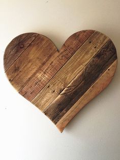 a heart shaped wooden cutting board sitting on top of a white wall