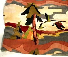 an artisticly designed piece of cloth with birds flying over it and trees in the background