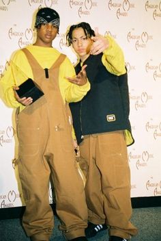 two young men standing next to each other in front of a wall with an american music awards logo on it