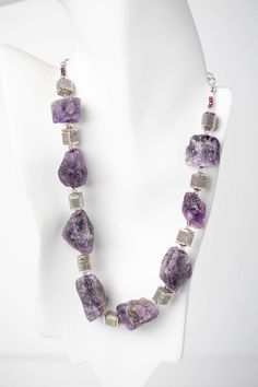 Shock and amaze everyone you know with this bold, beautiful necklace. It is made of amethyst rough cut stones with silver cubes and Swarovski© crystal. The silver adjustable length chain allows you to wear the necklace in a variety of styles. Amethyst is the perfect piece to wear with your favorite work clothes or your fancier attire. Silver Amethyst Crystal Necklaces, Silver Amethyst Stone Necklace, Silver Amethyst Crystal Necklace With Stones, Silver Amethyst Necklace With Raw Stone, Fancy Attire, Amethyst Rock, Rock Necklace, Necklace Amethyst, Murano Glass Beads