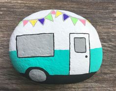 a painted rock with a camper on it