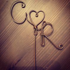 two heart shaped wire hangers sitting on top of a wooden table